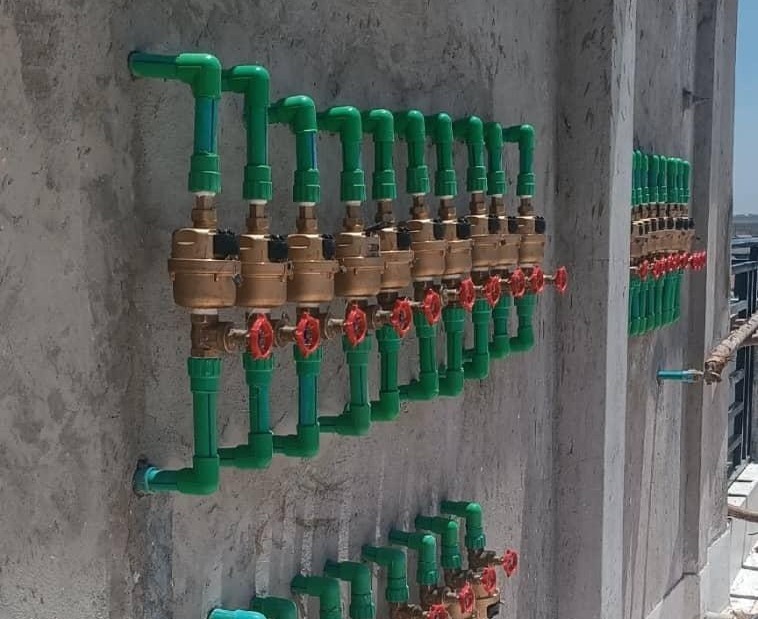 Row of brass valve manifolds and metering fittings installed by FlowTech